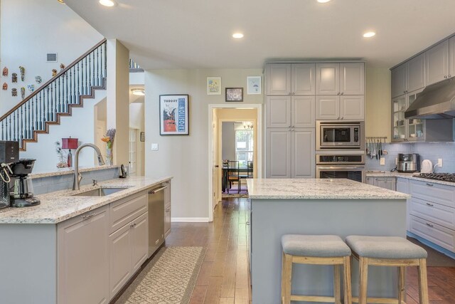 8132 Amelia Cv, Austin, TX 78750 - kitchen featuring stainless steel appliances, gray cabinetry, decorative backsplash, a kitchen island, and light stone counters