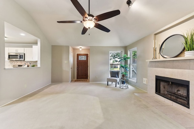 707 Clearwater Trl, Round Rock, TX 78664 - living room featuring ceiling fan, a tile fireplace, baseboards, light carpet, and vaulted ceiling