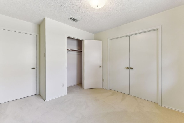 707 Clearwater Trl, Round Rock, TX 78664 - unfurnished bedroom featuring light colored carpet, multiple closets, and a textured ceiling