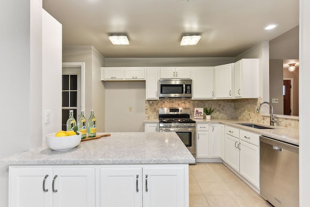 707 Clearwater Trl, Round Rock, TX 78664 - kitchen featuring appliances with stainless steel finishes, a sink, backsplash, and white cabinetry