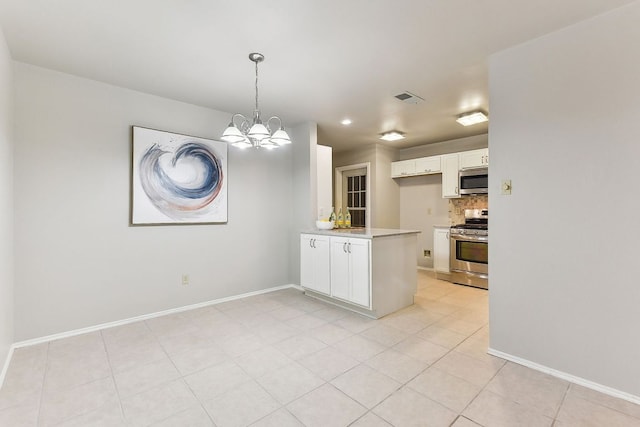 707 Clearwater Trl, Round Rock, TX 78664 - kitchen featuring appliances with stainless steel finishes, light countertops, white cabinets, a peninsula, and a chandelier