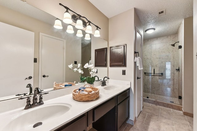 707 Clearwater Trl, Round Rock, TX 78664 - bathroom with a shower stall, double vanity, tile patterned floors, a textured ceiling, and baseboards
