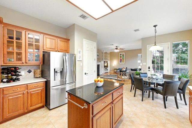 10220 N Chestnut Ridge Rd, Austin, TX 78726 - kitchen featuring stainless steel fridge, brown cabinets, ceiling fan, and decorative backsplash