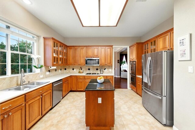 10220 N Chestnut Ridge Rd, Austin, TX 78726 - kitchen featuring stainless steel appliances, a sink, a center island, brown cabinetry, and decorative backsplash