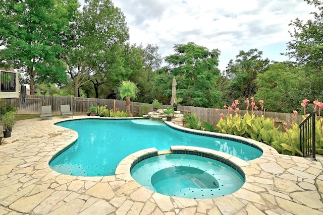 10220 N Chestnut Ridge Rd, Austin, TX 78726 - view of swimming pool with a fenced backyard, a pool with connected hot tub, view of wooded area, and a patio