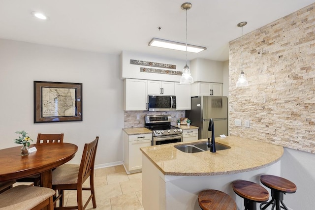 3404 American Dr Unit 1201, Lago Vista, TX 78645 - kitchen with appliances with stainless steel finishes, a sink, a breakfast bar area, decorative backsplash, and white cabinets