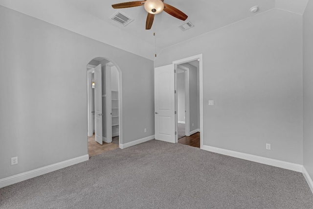 8316 Evelina Trl, Austin, TX 78737 - unfurnished bedroom featuring carpet flooring, arched walkways, a spacious closet, lofted ceiling, and baseboards