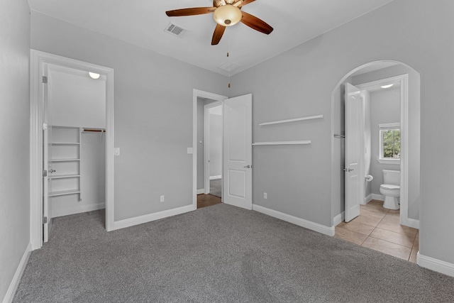 8316 Evelina Trl, Austin, TX 78737 - unfurnished bedroom featuring arched walkways, carpet, a spacious closet, connected bathroom, and baseboards