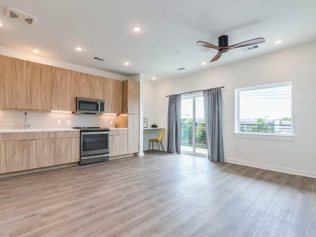 4802 S Congress Ave Unit 310, Austin, TX 78745 - kitchen with stainless steel appliances, modern cabinets, decorative backsplash, light wood-style floors, and recessed lighting