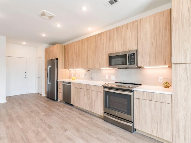 4802 S Congress Ave Unit 310, Austin, TX 78745 - kitchen with stainless steel appliances, light brown cabinetry, modern cabinets, and recessed lighting
