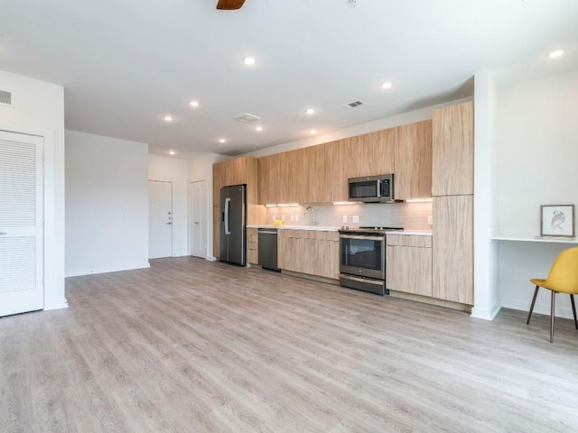 4802 S Congress Ave Unit 310, Austin, TX 78745 - kitchen featuring appliances with stainless steel finishes, modern cabinets, light countertops, light wood-style floors, and recessed lighting