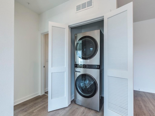 4802 S Congress Ave Unit 310, Austin, TX 78745 - laundry room featuring stacked washer / dryer and wood finished floors