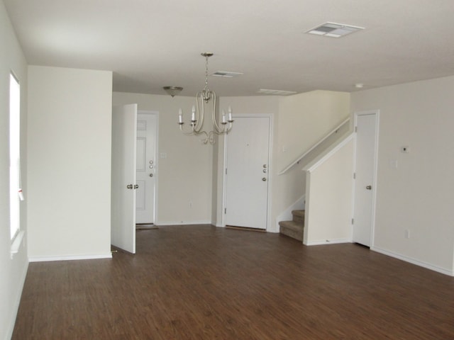 6708 Ferrystone Pass, Del Valle, TX 78617 - spare room featuring a chandelier, dark wood-style flooring, stairway, and baseboards