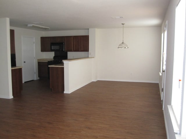 6708 Ferrystone Pass, Del Valle, TX 78617 - kitchen with black appliances, dark wood-type flooring, a peninsula, pendant lighting, and baseboards