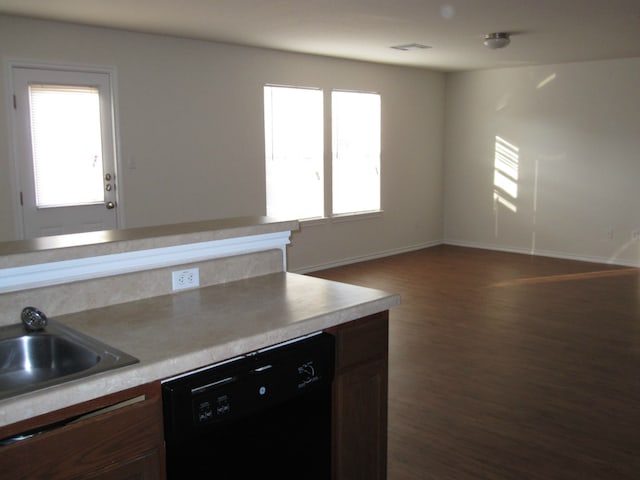 6708 Ferrystone Pass, Del Valle, TX 78617 - kitchen with dishwasher, dark wood finished floors, baseboards, light countertops, and a sink