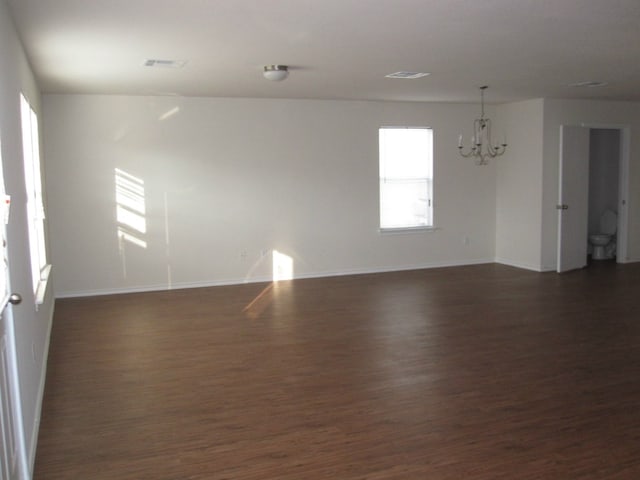 6708 Ferrystone Pass, Del Valle, TX 78617 - spare room with a chandelier, dark wood finished floors, and baseboards