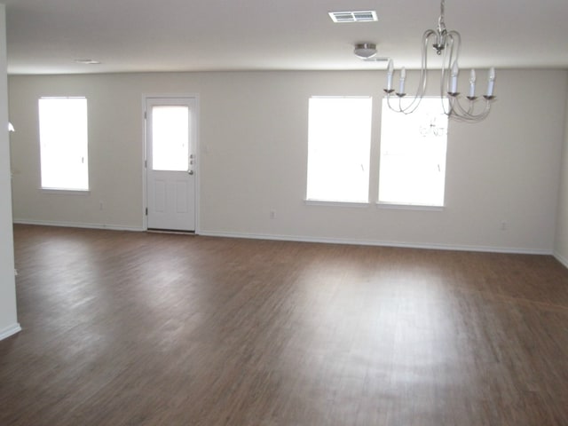 6708 Ferrystone Pass, Del Valle, TX 78617 - unfurnished dining area with a chandelier, dark wood-style flooring, and baseboards
