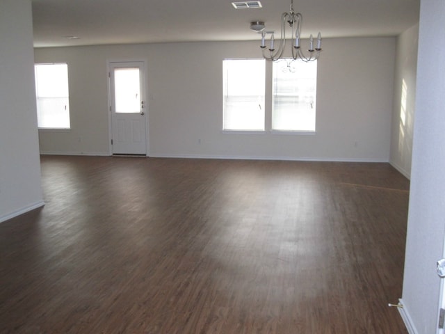 6708 Ferrystone Pass, Del Valle, TX 78617 - unfurnished room featuring a chandelier, dark wood-type flooring, and baseboards