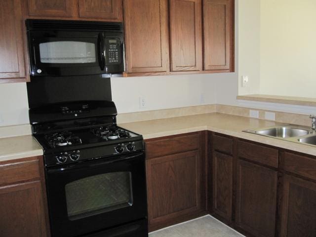 6708 Ferrystone Pass, Del Valle, TX 78617 - kitchen with black appliances, a sink, and light countertops