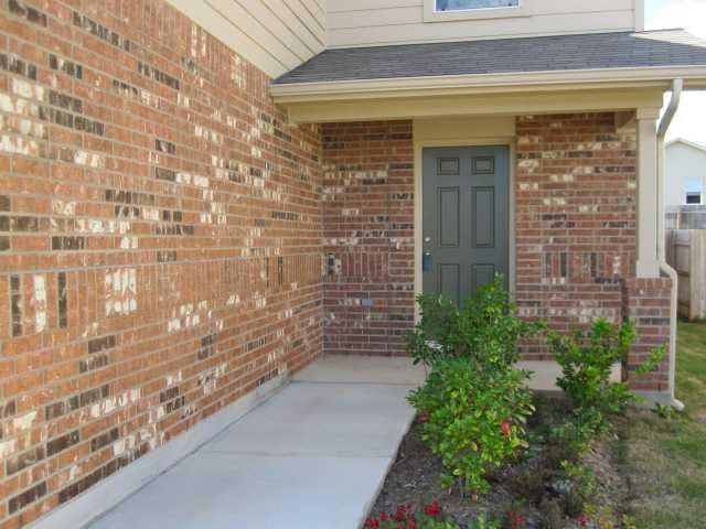 6708 Ferrystone Pass, Del Valle, TX 78617 - view of exterior entry with brick siding and roof with shingles
