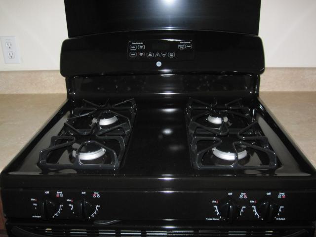 6708 Ferrystone Pass, Del Valle, TX 78617 - kitchen view of black gas range and decorative backsplash