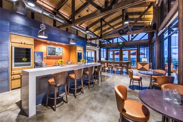 810 Sage Thrasher Cir, Dripping Springs, TX 78620 - community bar area with high vaulted ceiling, beverage cooler, finished concrete flooring, wooden ceiling with exposed beams, and pendant lighting