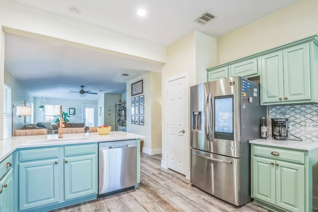 1918 Sand Creek Rd, Cedar Park, TX 78613 - kitchen featuring stainless steel appliances, open floor plan, a sink, light countertops, and decorative backsplash