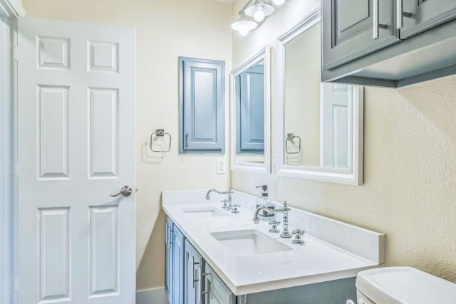 1918 Sand Creek Rd, Cedar Park, TX 78613 - bathroom featuring toilet, double vanity, and a textured wall