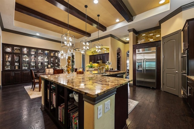 5700 Cherokee Draw Rd, Austin, TX 78738 - kitchen featuring appliances with stainless steel finishes, beamed ceiling, arched walkways, dark brown cabinetry, and light stone counters