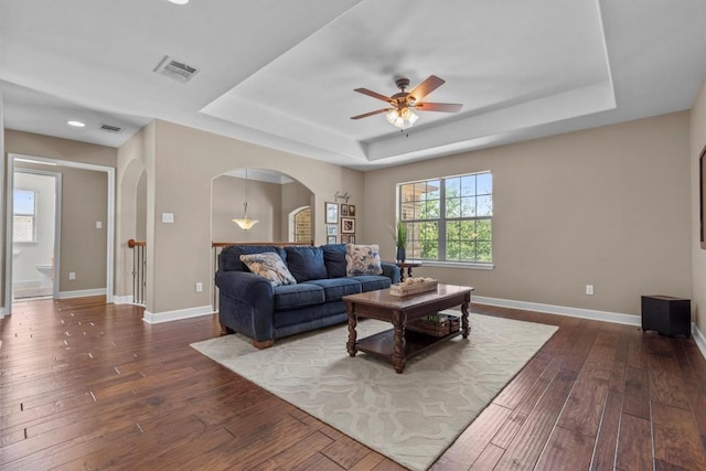 2700 Outlook Ridge Loop, Leander, TX 78641 - living area with a tray ceiling, arched walkways, dark wood-style floors, a ceiling fan, and recessed lighting