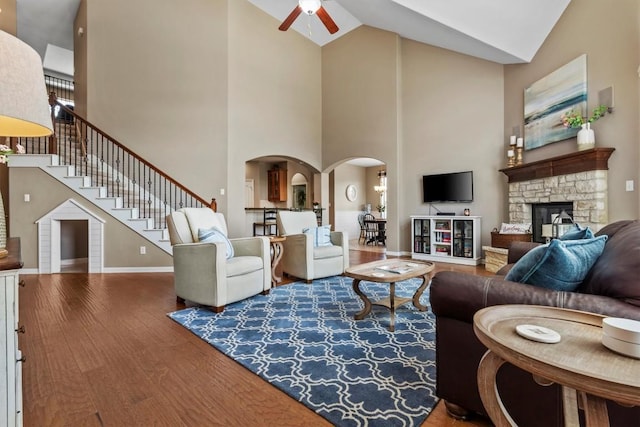 2700 Outlook Ridge Loop, Leander, TX 78641 - living room with a ceiling fan, wood finished floors, high vaulted ceiling, arched walkways, and stairs