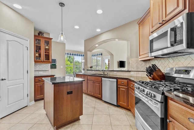 2700 Outlook Ridge Loop, Leander, TX 78641 - kitchen featuring appliances with stainless steel finishes, a kitchen island, backsplash, glass insert cabinets, and recessed lighting