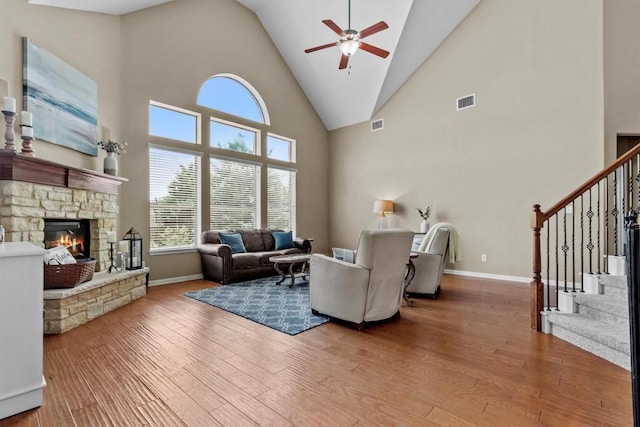 2700 Outlook Ridge Loop, Leander, TX 78641 - living room featuring a ceiling fan, stairs, wood finished floors, high vaulted ceiling, and a stone fireplace