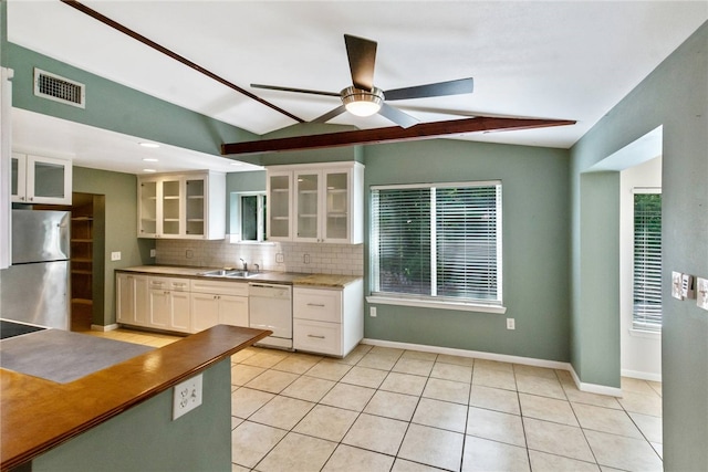 17903 Lafayette Park Rd, Jonestown, TX 78645 - kitchen with dishwasher, freestanding refrigerator, lofted ceiling, a sink, and backsplash