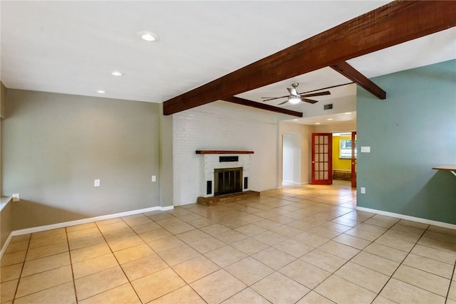 17903 Lafayette Park Rd, Jonestown, TX 78645 - unfurnished living room featuring light tile patterned floors, beamed ceiling, a ceiling fan, a brick fireplace, and baseboards