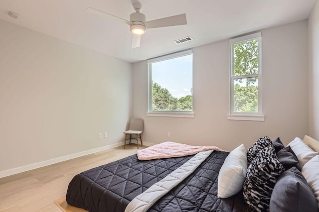 900 S 1st St Unit 212, Austin, TX 78704 - bedroom featuring multiple windows, light wood-type flooring, baseboards, and a ceiling fan