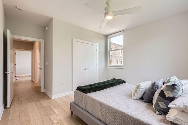 900 S 1st St Unit 212, Austin, TX 78704 - bedroom with light wood-style flooring, a closet, baseboards, and ceiling fan