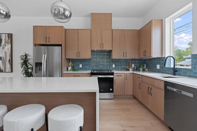 6410 Cannonleague Dr Unit 1, Austin, TX 78745 - kitchen featuring stainless steel appliances, a sink, light countertops, decorative backsplash, and a kitchen bar