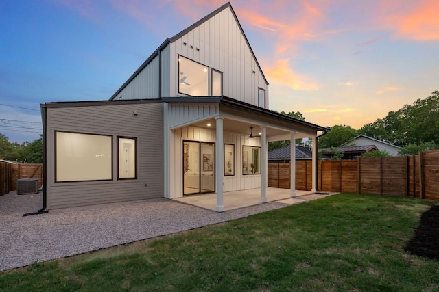 6410 Cannonleague Dr Unit 1, Austin, TX 78745 - back of property at dusk with board and batten siding, a patio area, and central air condition unit