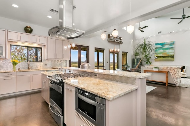 165 Highridge Ln, Fredericksburg, TX 78624 - kitchen featuring stainless steel gas stove, island exhaust hood, concrete flooring, decorative backsplash, and ceiling fan