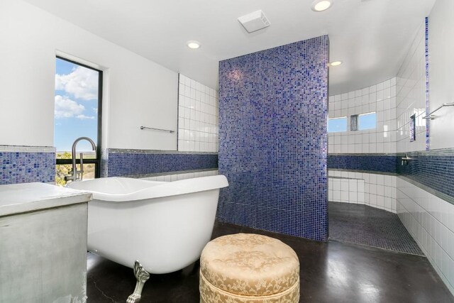 165 Highridge Ln, Fredericksburg, TX 78624 - full bathroom with tile walls, a freestanding bath, concrete flooring, and recessed lighting
