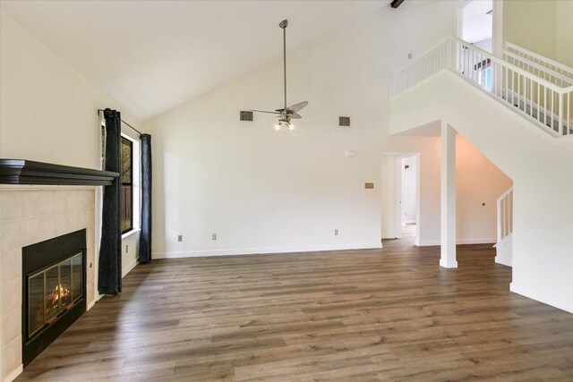 1811 Hatch Rd, Cedar Park, TX 78613 - unfurnished living room with ceiling fan, a tiled fireplace, high vaulted ceiling, wood finished floors, and baseboards