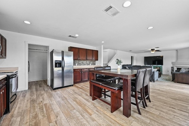 585 Siebert Dr, Kyle, TX 78640 - kitchen with stainless steel refrigerator with ice dispenser, range with electric cooktop, ceiling fan, light wood-style floors, and recessed lighting