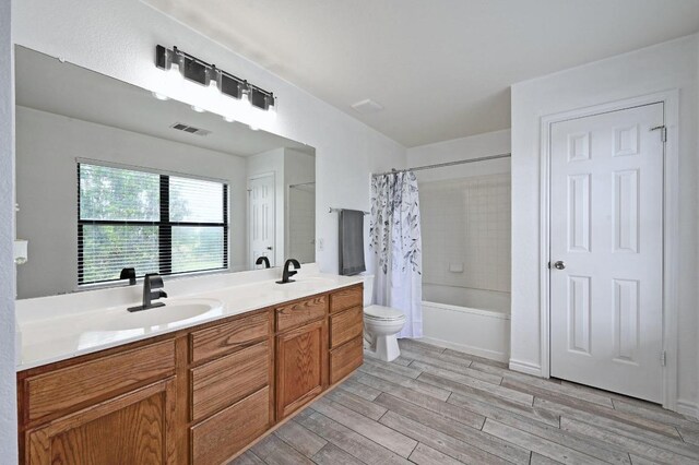 585 Siebert Dr, Kyle, TX 78640 - bathroom with wood finished floors, shower / bath combo, and double vanity