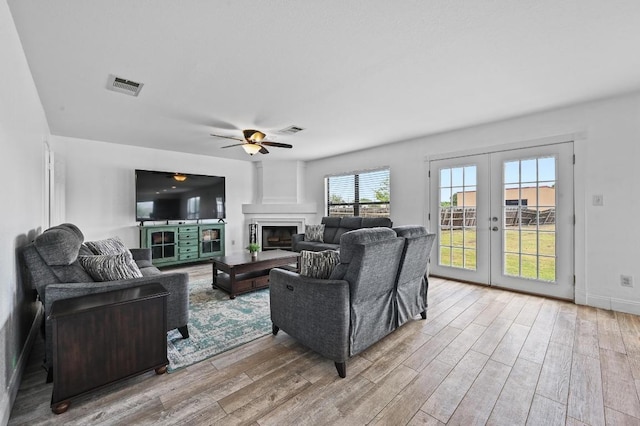 585 Siebert Dr, Kyle, TX 78640 - living room featuring wood finished floors, french doors, a fireplace, and ceiling fan