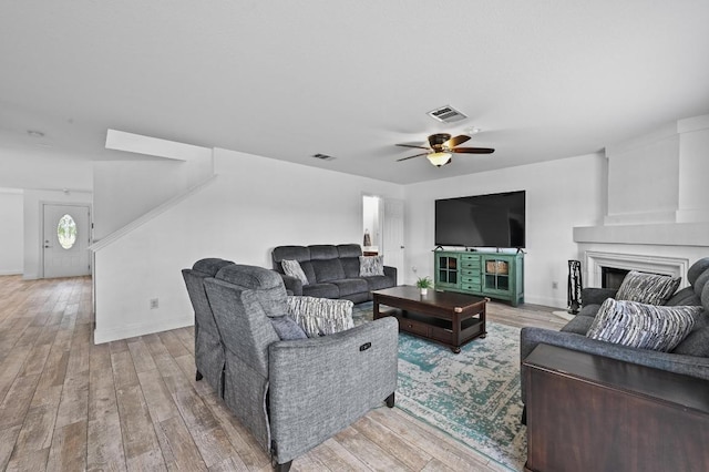 585 Siebert Dr, Kyle, TX 78640 - living area featuring a ceiling fan, a fireplace, and light wood-type flooring