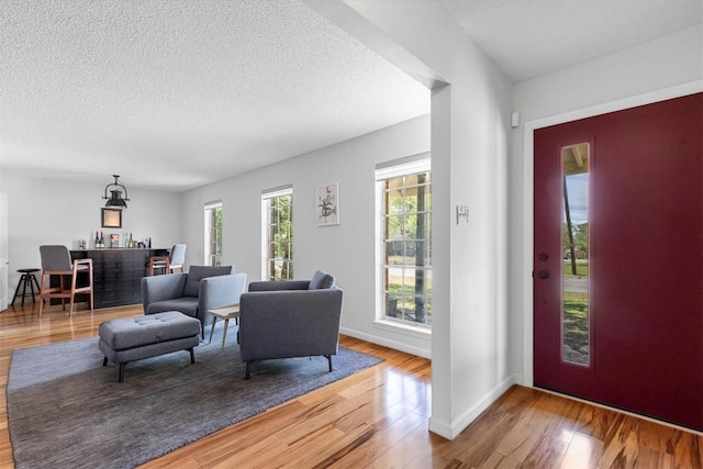 3104 Rexford Dr, Austin, TX 78723 - entrance foyer with wood finished floors, a bar, and a textured ceiling