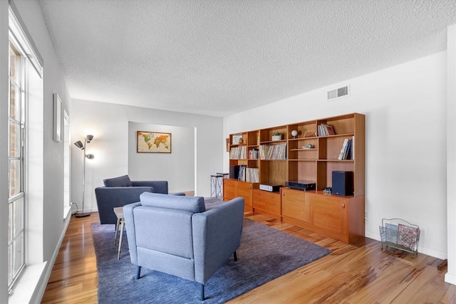 3104 Rexford Dr, Austin, TX 78723 - living room featuring a textured ceiling, wood finished floors, and baseboards