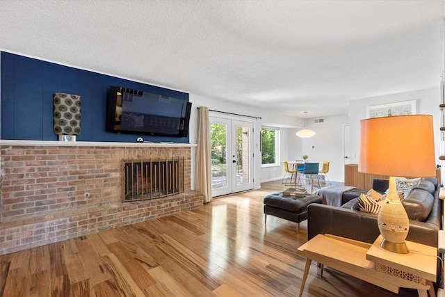 3104 Rexford Dr, Austin, TX 78723 - living area with wood finished floors, a textured ceiling, french doors, and a fireplace