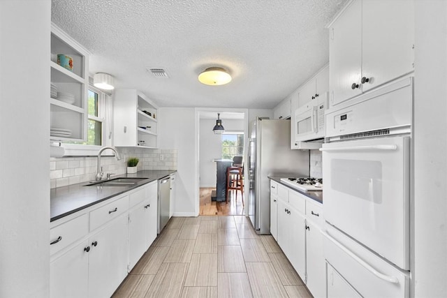 3104 Rexford Dr, Austin, TX 78723 - kitchen with open shelves, a sink, stainless steel appliances, a warming drawer, and decorative backsplash